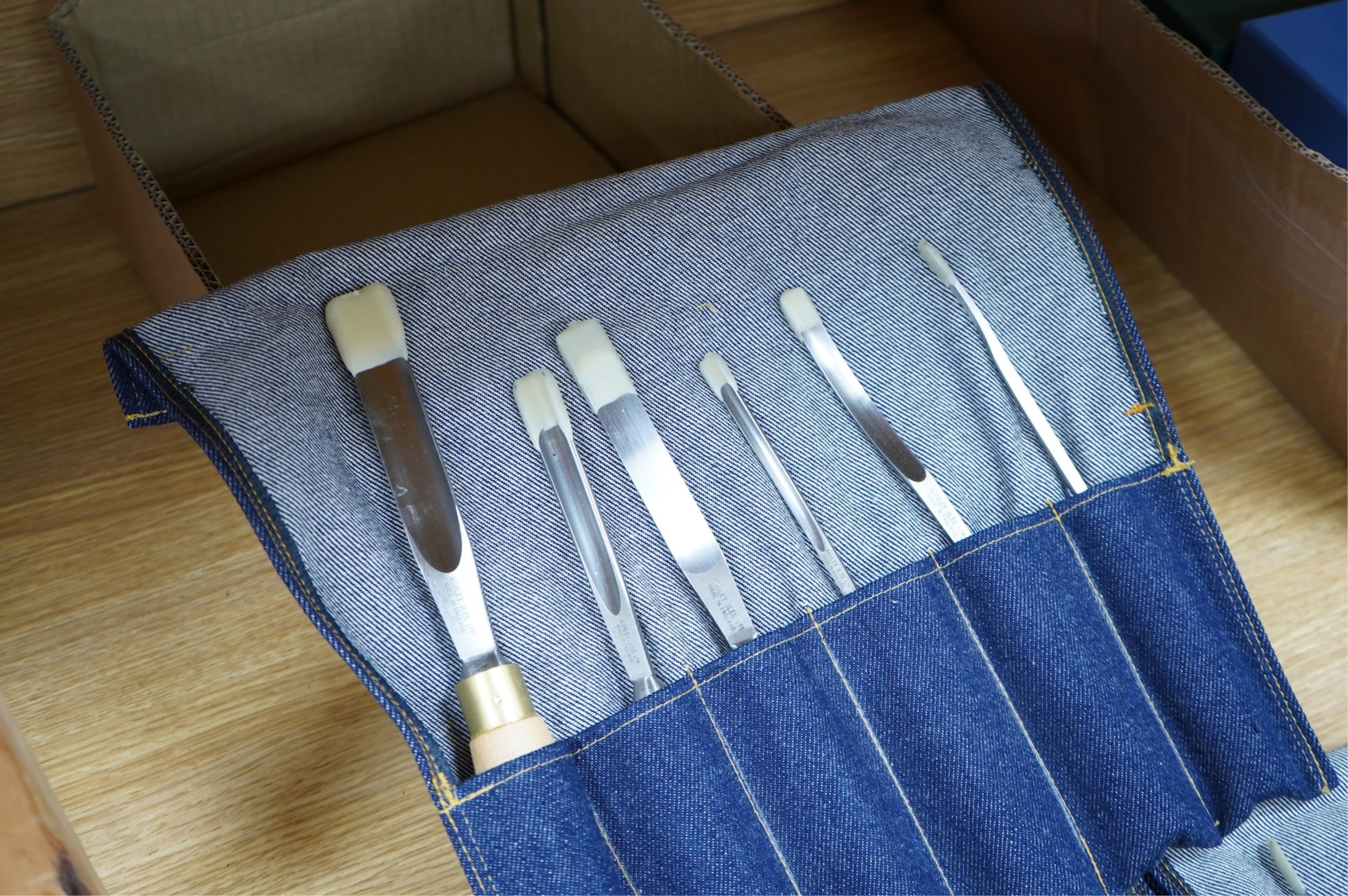 Three sets of Ashley Iles wood carving tools, contained within denim tool rolls; the York Set, the Supplementary Set No.Two, and the Supplementary Set No.Three, each comprising of six chisels (18 chisels in total)